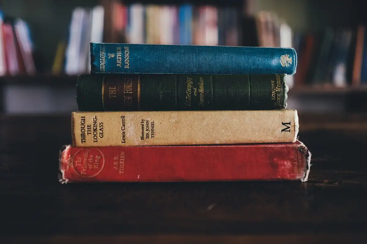 Teanc de volume vechi, cu cotor colorat, așezat pe un raft de bibliotecă